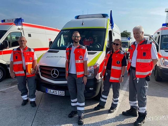 Aktive Helferinnen und Helfer des Bereitschaftsdienstes vom DRK Kreisverband Eisenach e.V. vor ihren Einsatzfahrzeugen bei sonnigem Wetter.