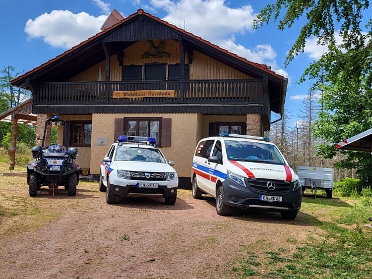 Einsatzfahrzeuge der Bergwacht: ein ATV, ein Geländewagen und ein Transporter, stehen vor der Bergrettungsstation Waldhaus Auerhahn.